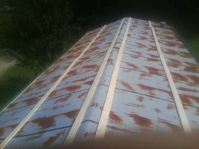 Rusted metal roof panels with new wood purlins before replacement — Storm Damage Roof Repair in Bellerose by Roofing Brothers