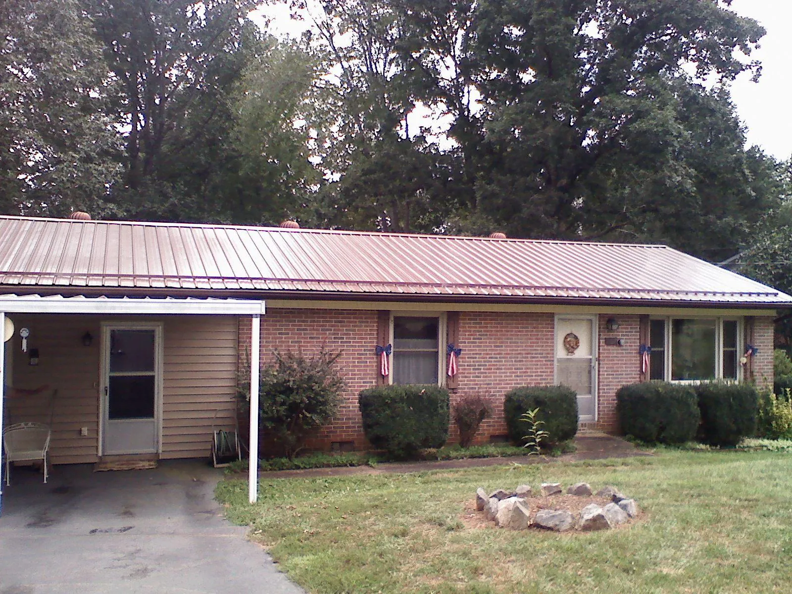 Bronze metal roof and carport on a brick ranch home — Roof Repair work by our crew in Bellerose